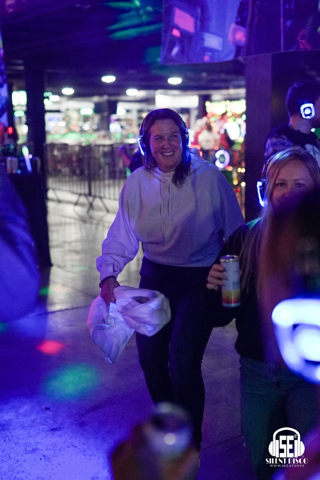 A silent disco guest at an SE2 Home for the Holidays event wearing wireless headphones.