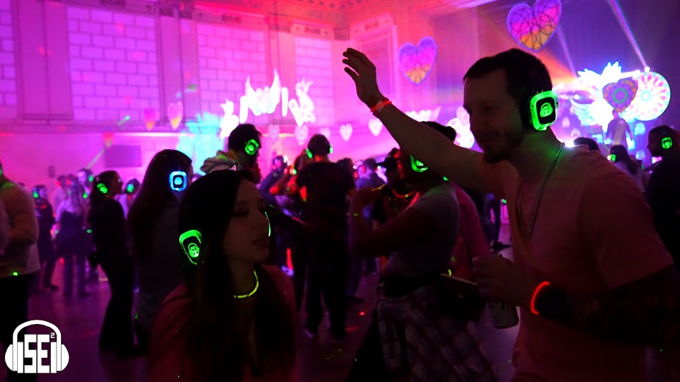 Crowd dancing with glowing SE2 Silent Disco headphones at a Buffalo event